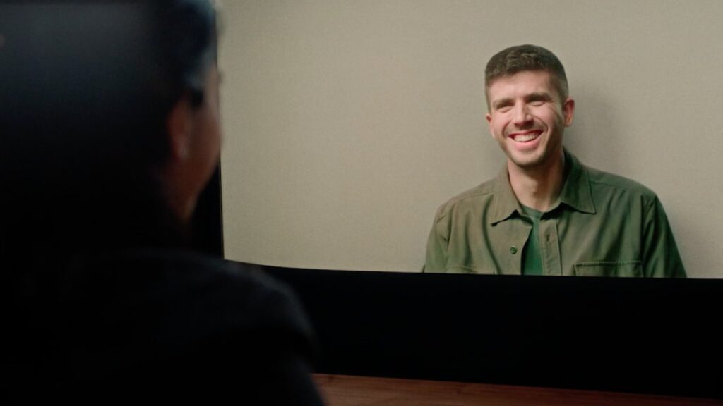 Man smiles while appearing lifelike on a Beam Device screen